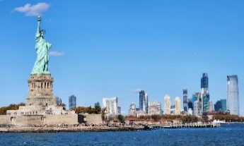 A statue of liberty with a city in the backgroundDescription automatically generated